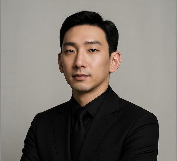 Black and white portrait of a dance instructor posing in front of a dark background.